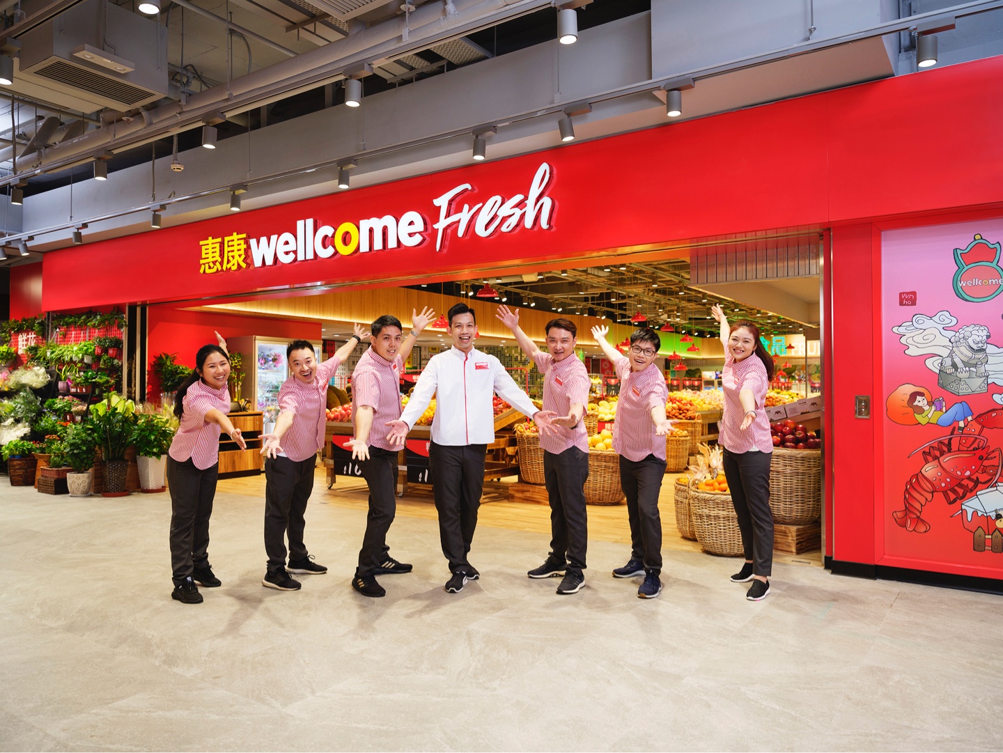 Happy team members in front of Wellcome store